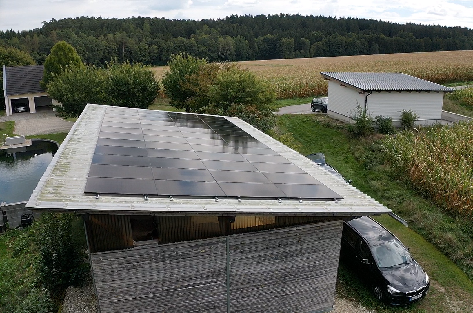 Luftaufnahme einer fertigen PV-Anlage auf dem Flachdach eines Holzschuppens