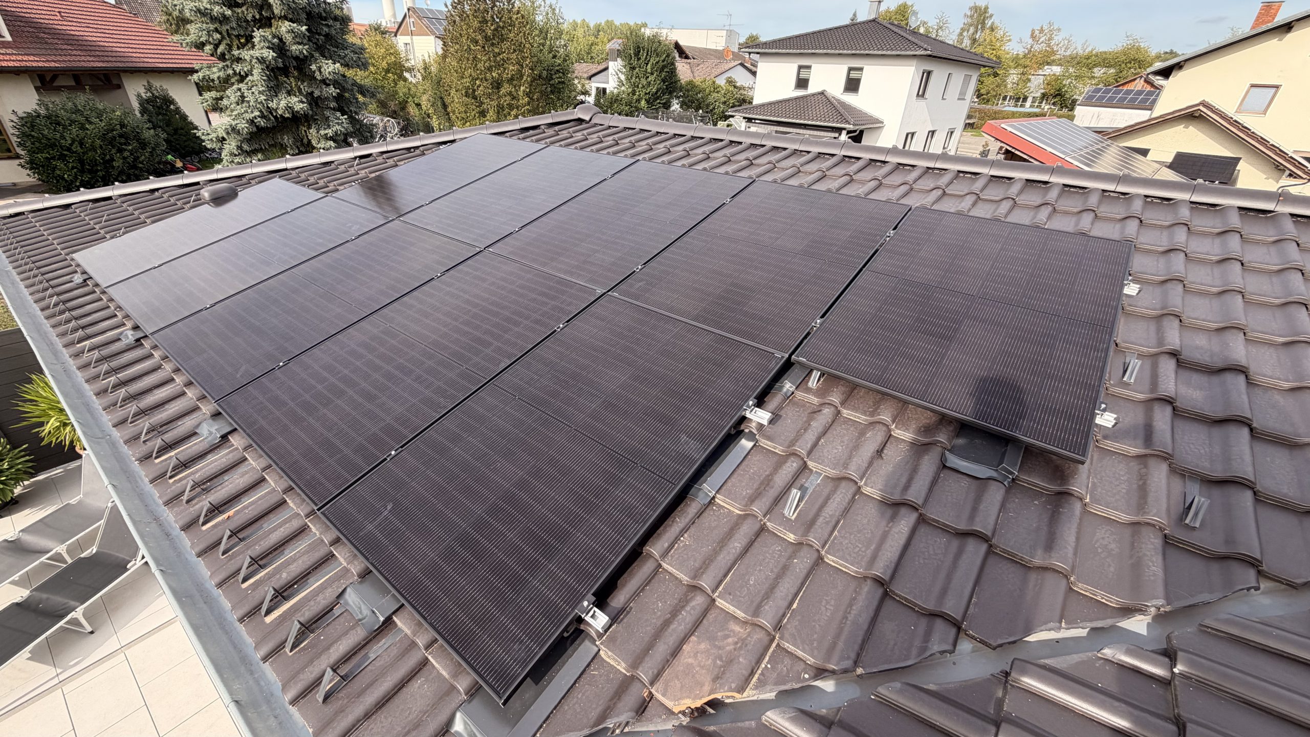 Schwarze PV-Module auf einem Ziegeldach, Drohnenaufnahme